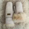 beli rukavici 3 | Milvena | Милвена - Български кожени изделия от агнешка кожа Pair of light gray suede mittens with fluffy fur cuffs resting on a cream faux‑fur background.