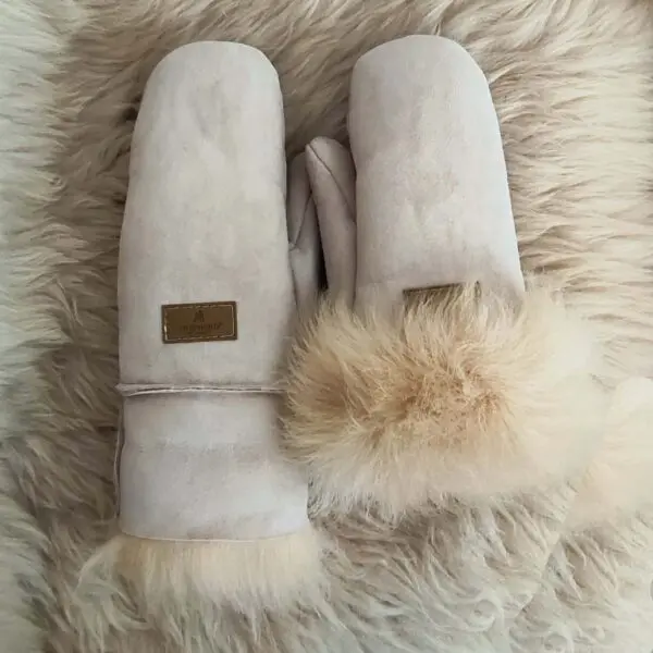 beli rukavici 3 | Milvena | Милвена - Български кожени изделия от агнешка кожа Pair of light gray suede mittens with fluffy fur cuffs resting on a cream faux‑fur background.